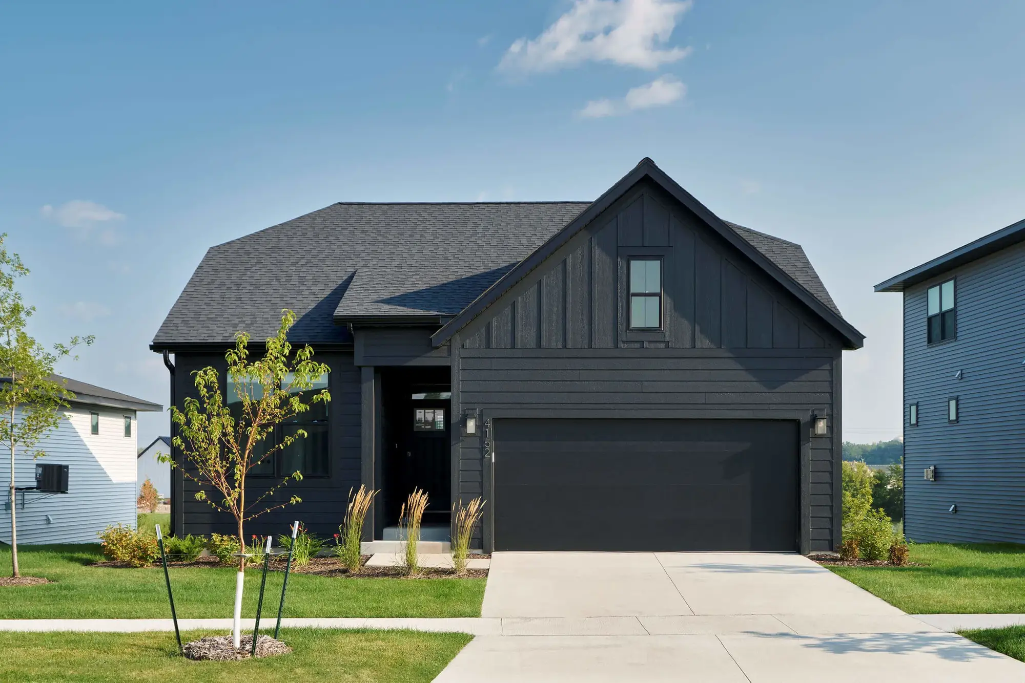 Modern black house with two-car garage.