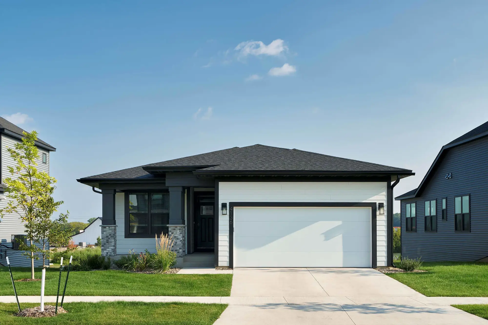 Modern suburban house with driveway and lawn.