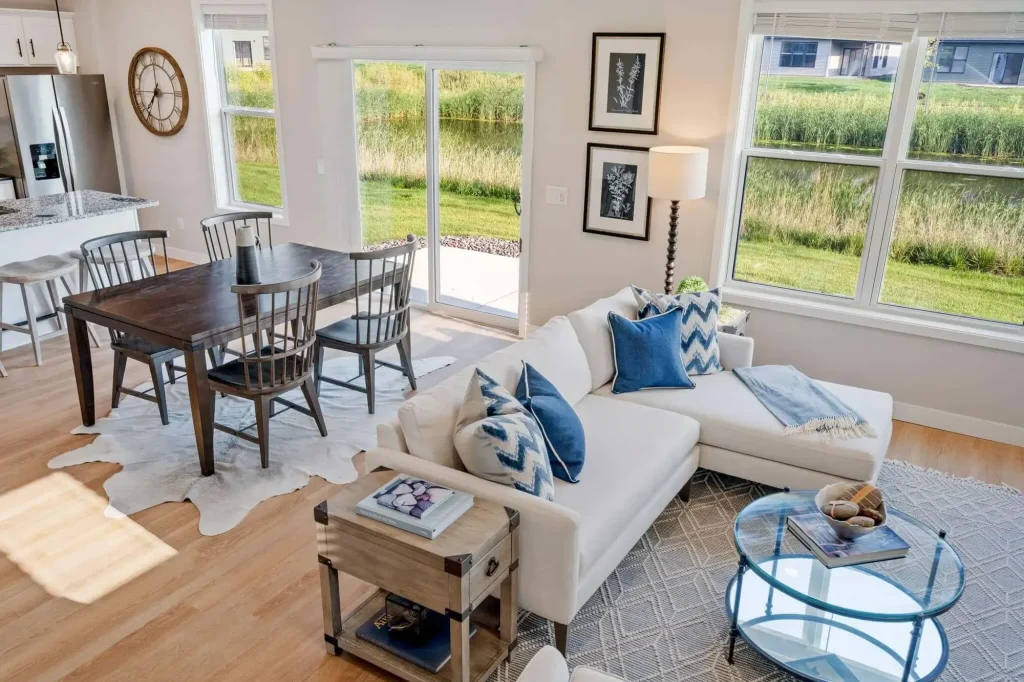 Modern living room with dining area and large windows.