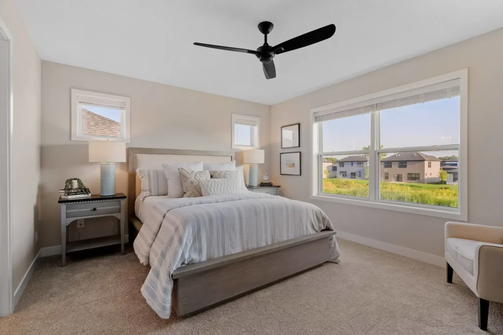 Modern bedroom with ceiling fan and large window